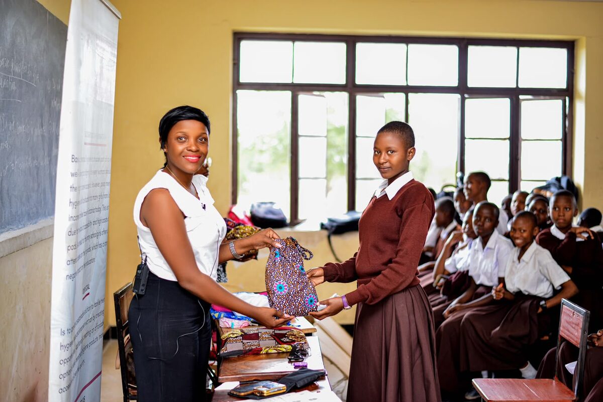 Ane, Binti-Koordinatorin vor Ort, übergibt Binti-Sets an Mädchen der Mvomero Secondary School